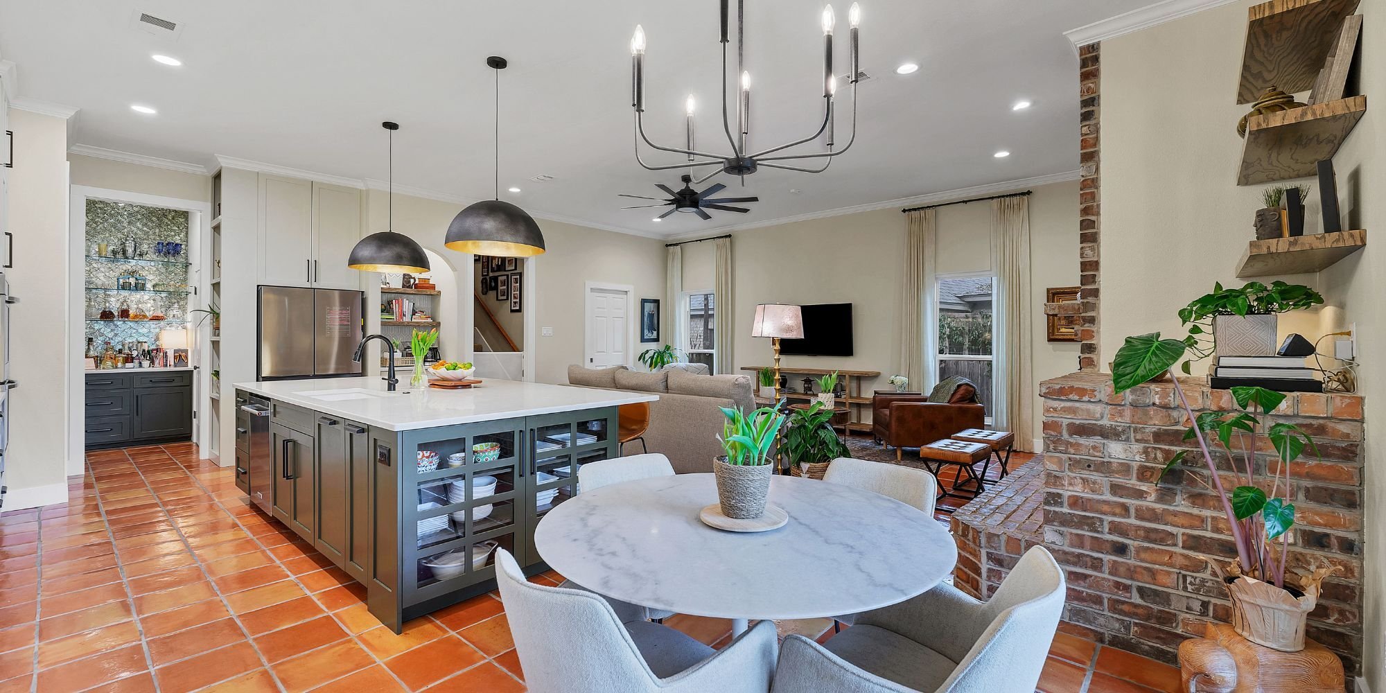 Transitional kitchen and sitting room remodel in San Antonio with modern island, textured finishes, and custom built-ins by Hill H