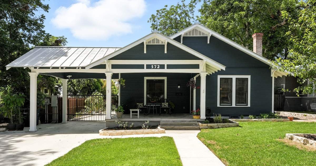 Custom home exterior in San Antonio by Hill Haven Homes, featuring classic blue siding, a front porch, and carport