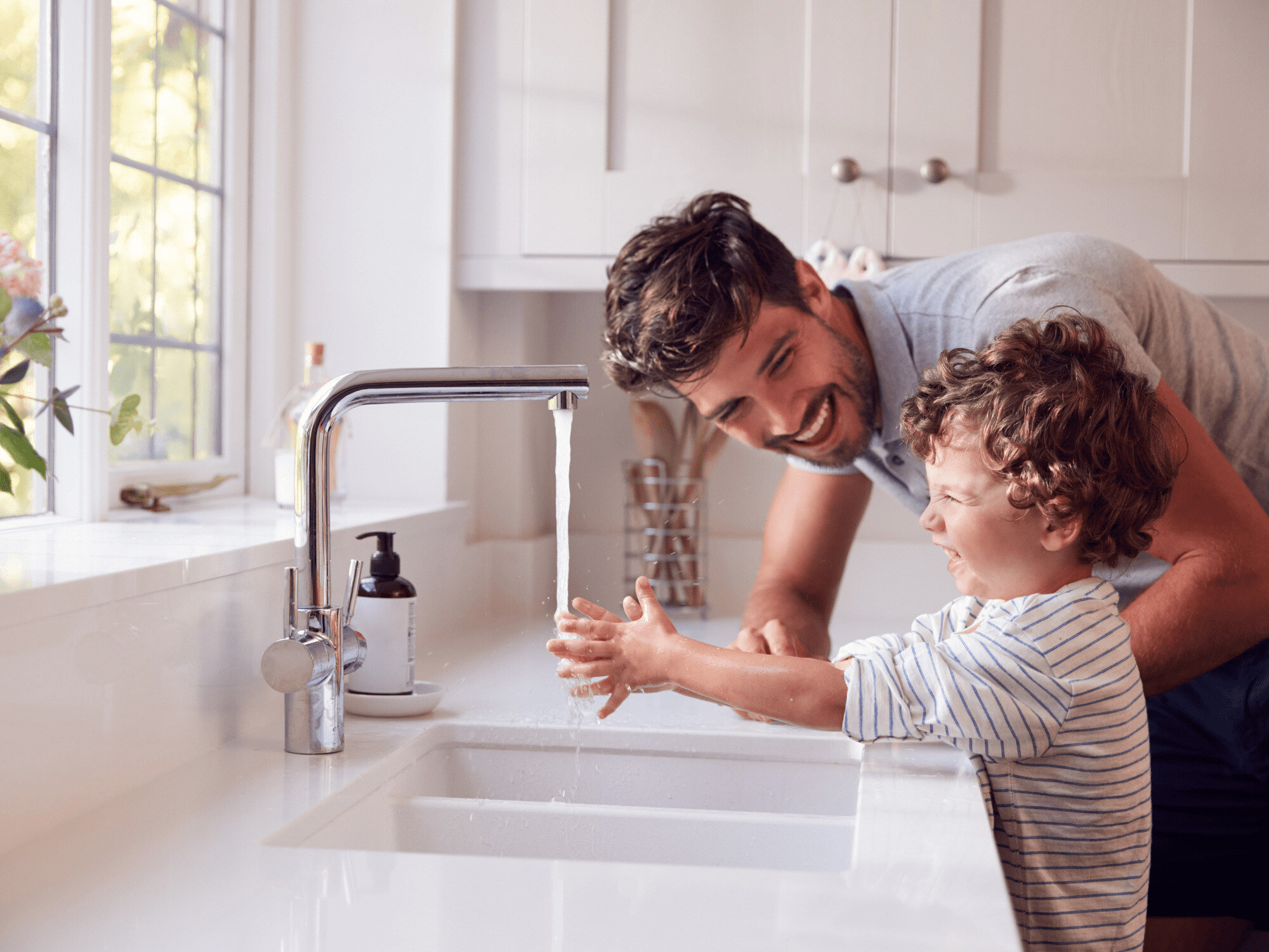 Stock Image of Man and Child Washing Hands in Kitchen