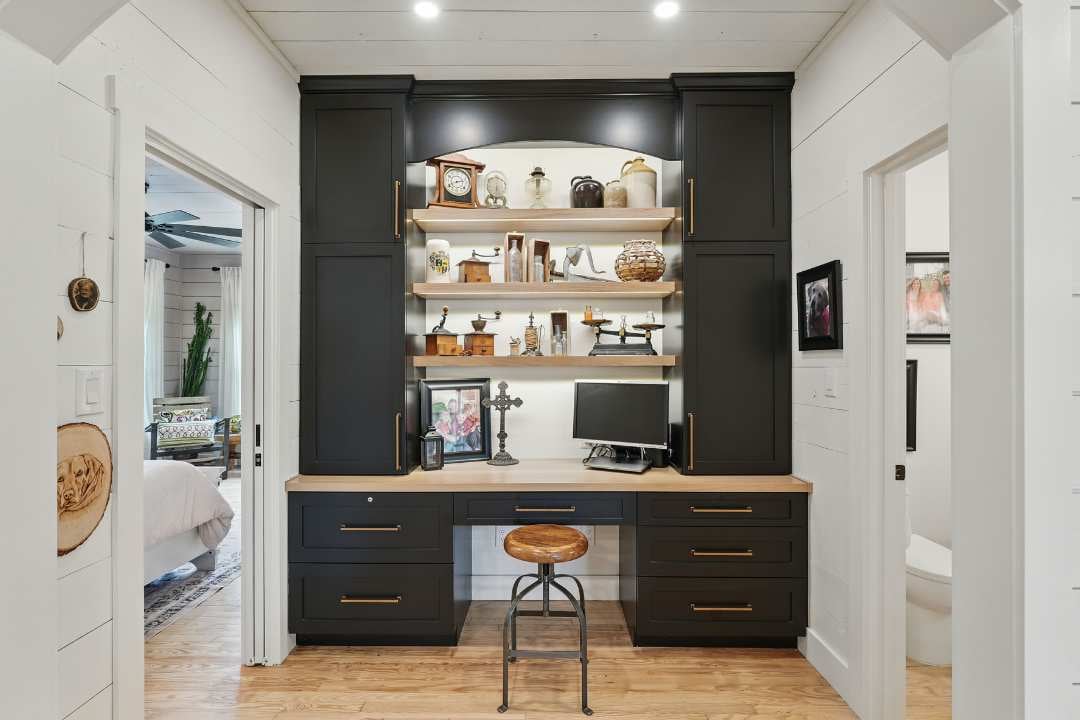 Custom built-in desk nook with black cabinetry, wood shelving, and vintage decor in a remodeled San Antonio home
