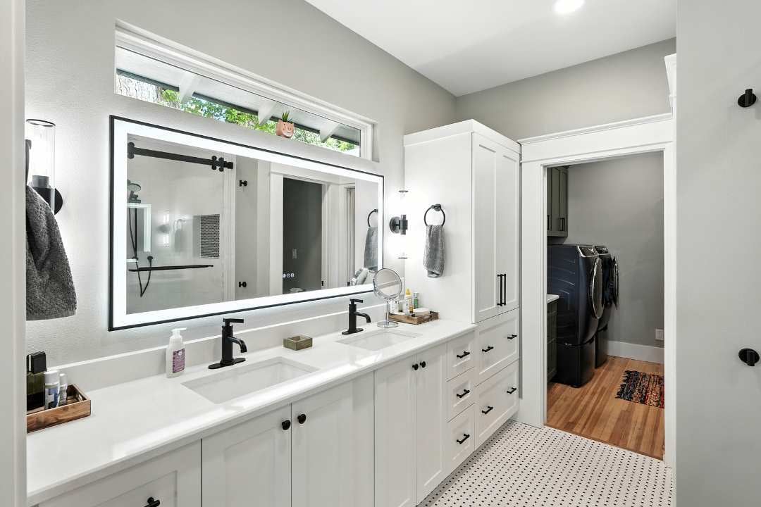 Modern bathroom remodel with dual vanity, black fixtures, and built-in storage by Hill Haven Homes in San Antonio