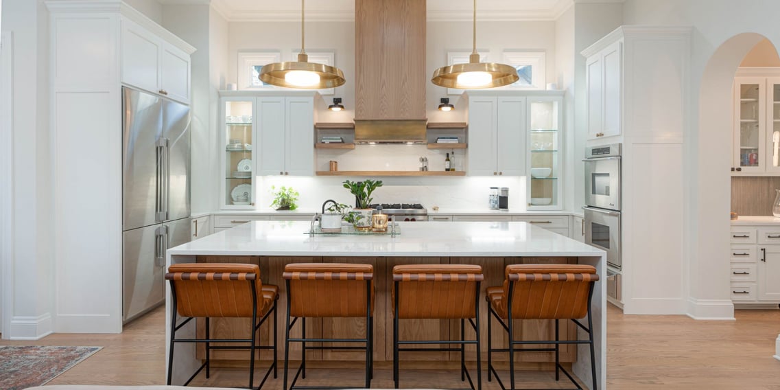 Bright San Antonio kitchen renovation with leather bar stools, gold lighting, and custom cabinetry by Hill Haven Homes