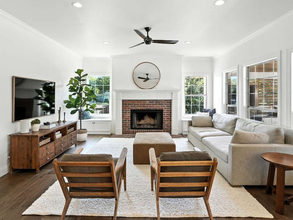 Home addition with brick fireplace and natural light by Hill Haven Homes in San Antonio