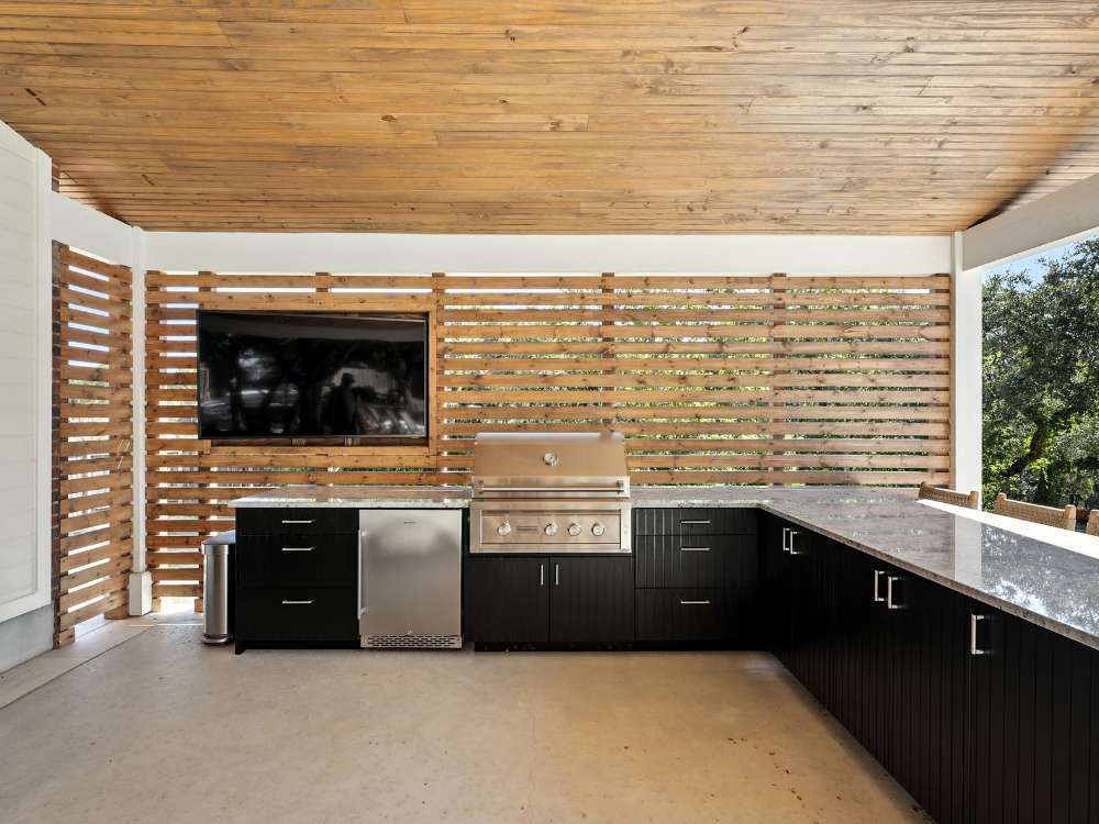 Outdoor kitchen with stainless grill and TV by Hill Haven Homes in San Antonio Outdoor kitchen with stainless grill and TV by Hill Haven Homes in San Antonio